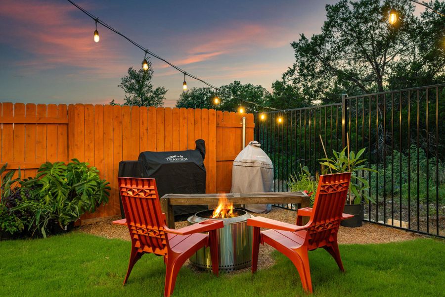 An inviting backyard setting offers a cozy fire pit, perfect for evening gatherings under string lights. An inviting backyard setting offers a cozy fire pit, perfect for evening gatherings under string lights.