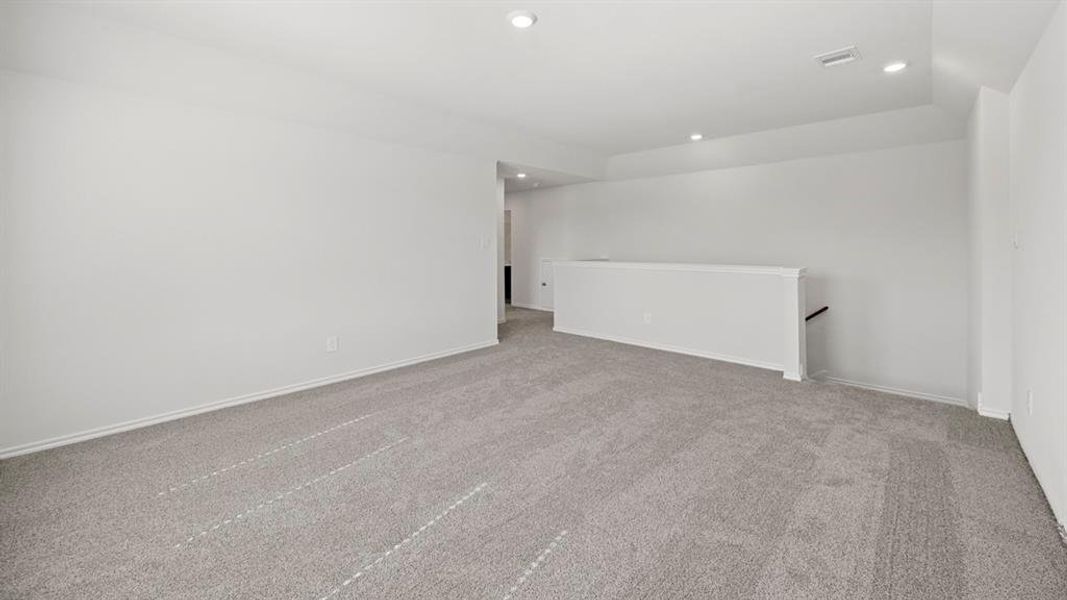 Carpeted empty room with recessed lighting and baseboards