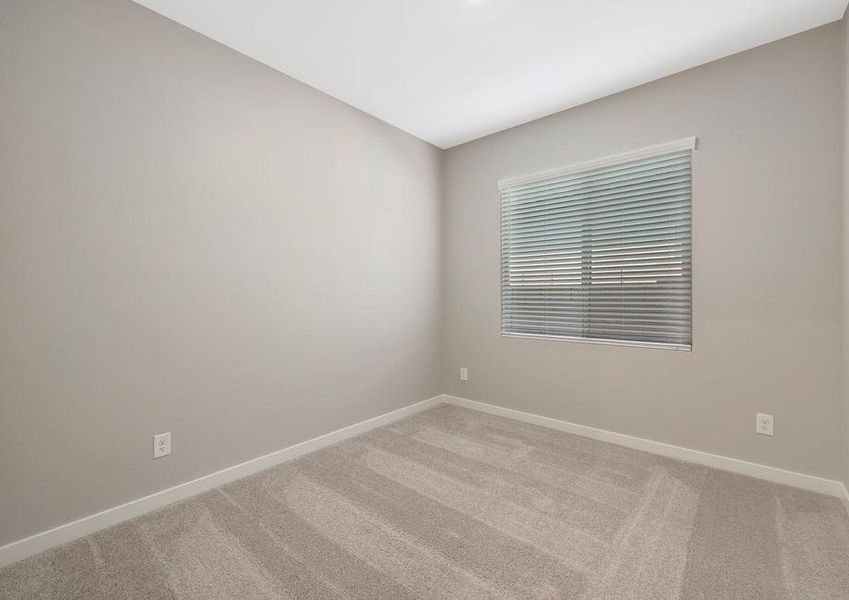 Guest bedroom with recessed lighting and a window that creates a bright space.