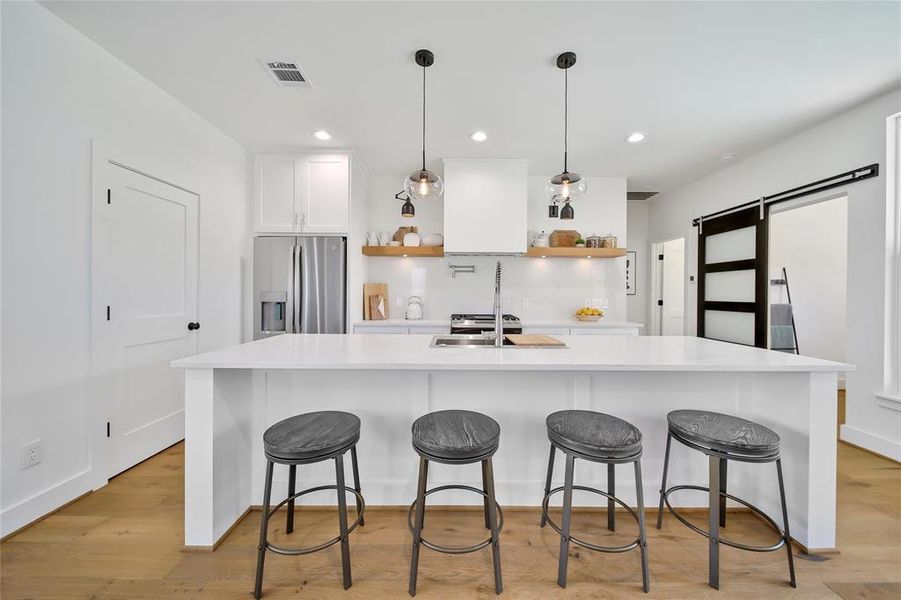 This photo was taken in another staged property with the same finishes and layout. View of the kitchen from the living room.