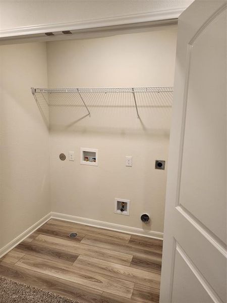 Laundry room with light wood-type flooring, washer hookup, and hookup for an electric dryer Laundry room with light wood-type flooring, washer hookup, and hookup for an electric dryer