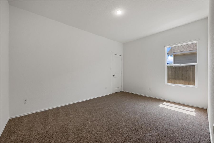 Spare room with dark carpet and baseboards Spare room with dark carpet and baseboards