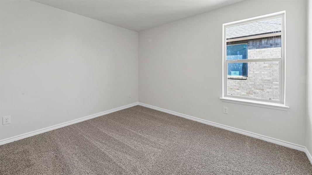 Carpeted spare room with baseboards