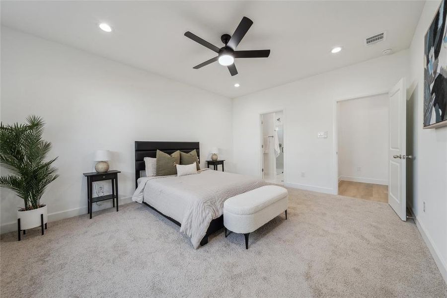 Carpeted primary bedroom (1st floor) featuring ceiling fan