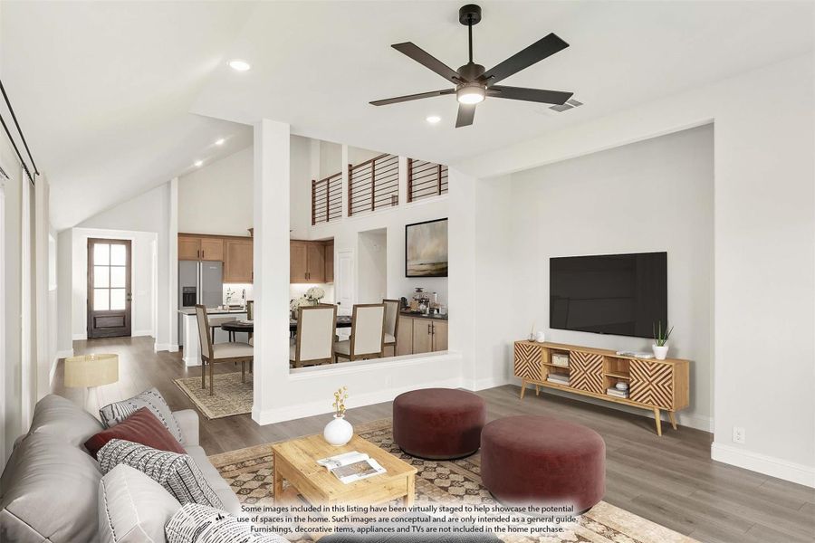 Open-concept living room with vaulted ceiling, ceiling fan, hardwood floors, and view into kitchen and dining area Open-concept living room with vaulted ceiling, ceiling fan, hardwood floors, and view into kitchen and dining area