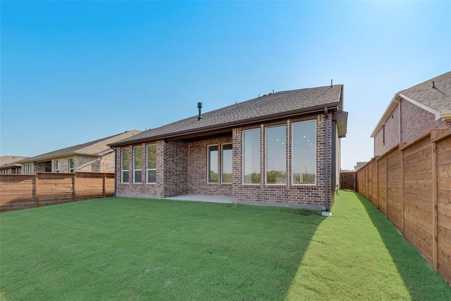 Rear view of property with a yard