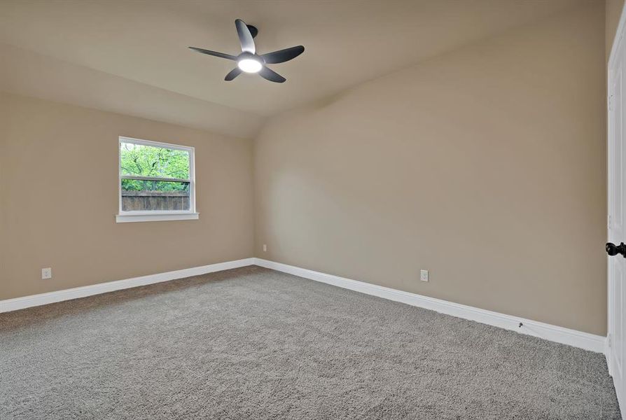 Spare room featuring ceiling fan, baseboards, lofted ceiling, and carpet Spare room featuring ceiling fan, baseboards, lofted ceiling, and carpet