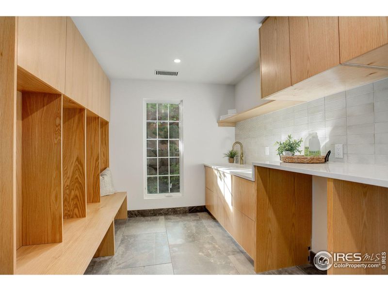 Laundry room with Menorca Marble Antico tile and custom white oak cabinets