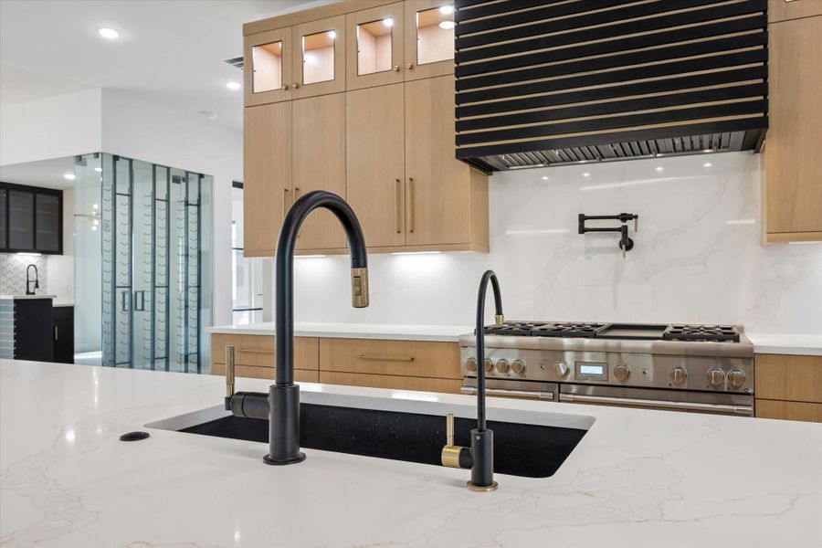 The wide under-mount composite granite sink looks good and is highly durable. High end specialty plumbing fixtures like this one are used throughout the house.