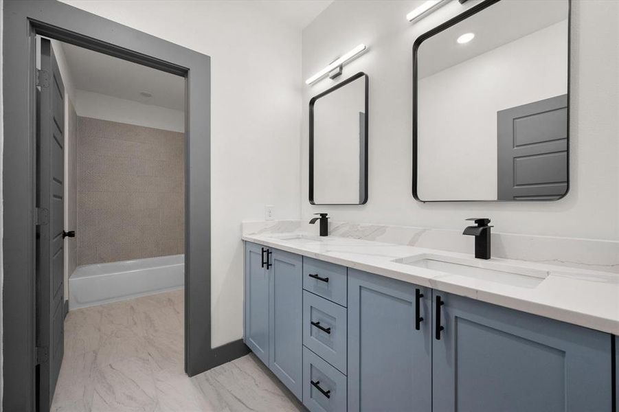 Bathroom with baseboards, double vanity, marble finish floor, and a sink Bathroom with baseboards, double vanity, marble finish floor, and a sink