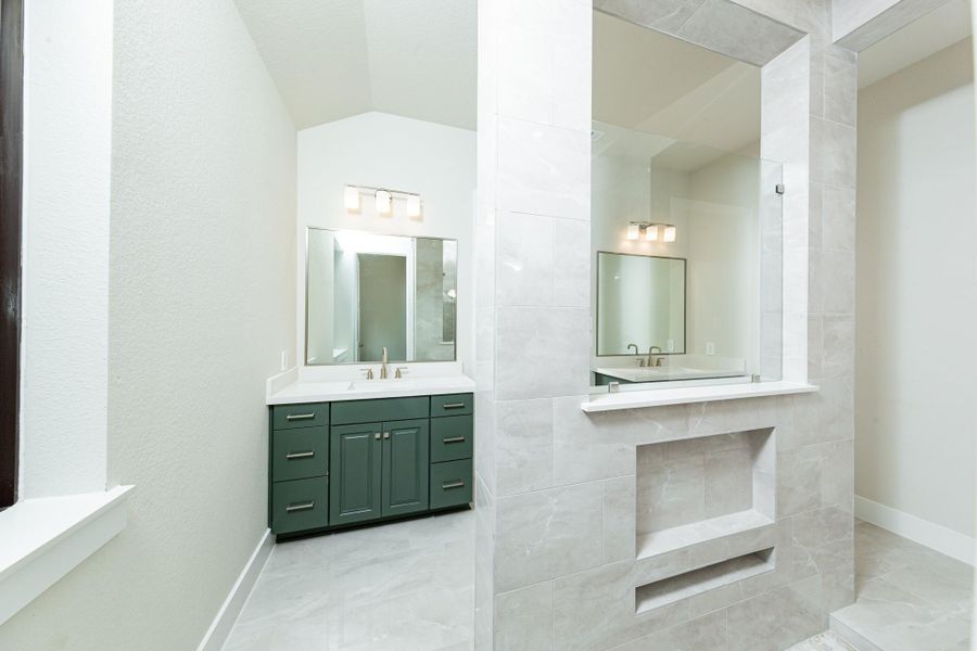 Additional view of the primary bathroom vanity area and open walk-in shower.