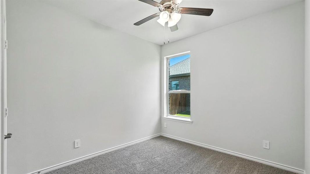 Bedroom featuring light gray wall paint, gray carpeting, a single window with white trim, and a ceiling fan with integrated lighting Bedroom featuring light gray wall paint, gray carpeting, a single window with white trim, and a ceiling fan with integrated lighting