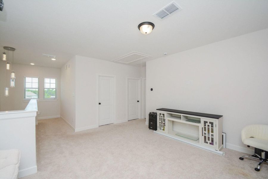 Filled with natural light, the second-floor game room serves as the centerpiece of the upstairs living area, offering convenient access to the secondary bedrooms and full bathroom. The open layout creates a welcoming space that balances privacy with connection, making it ideal for relaxing, entertaining, or everyday living.
