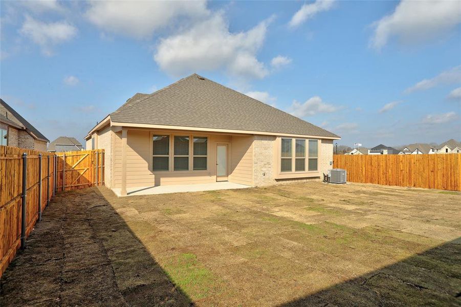 Back of property with a yard, central AC, and a patio