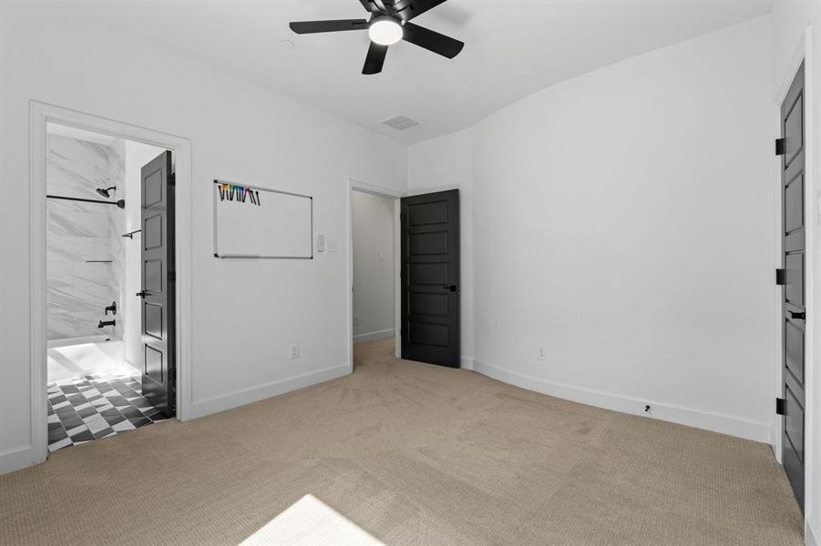 Unfurnished bedroom with a ceiling fan, light colored carpet, and ensuite bathroom Unfurnished bedroom with a ceiling fan, light colored carpet, and ensuite bathroom