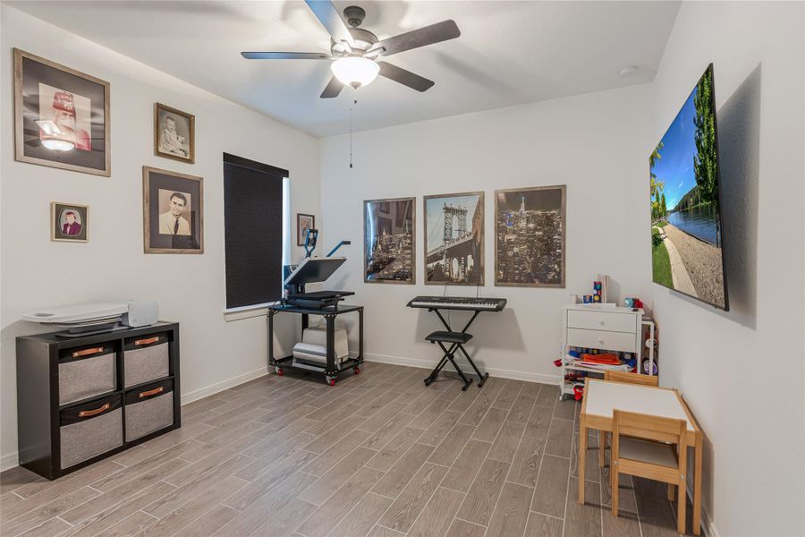 This is the 4th bedroom. Showing plenty of space for your guest or home/office/craft area. Also displaying the wood like tile that is flowing all through out the home.