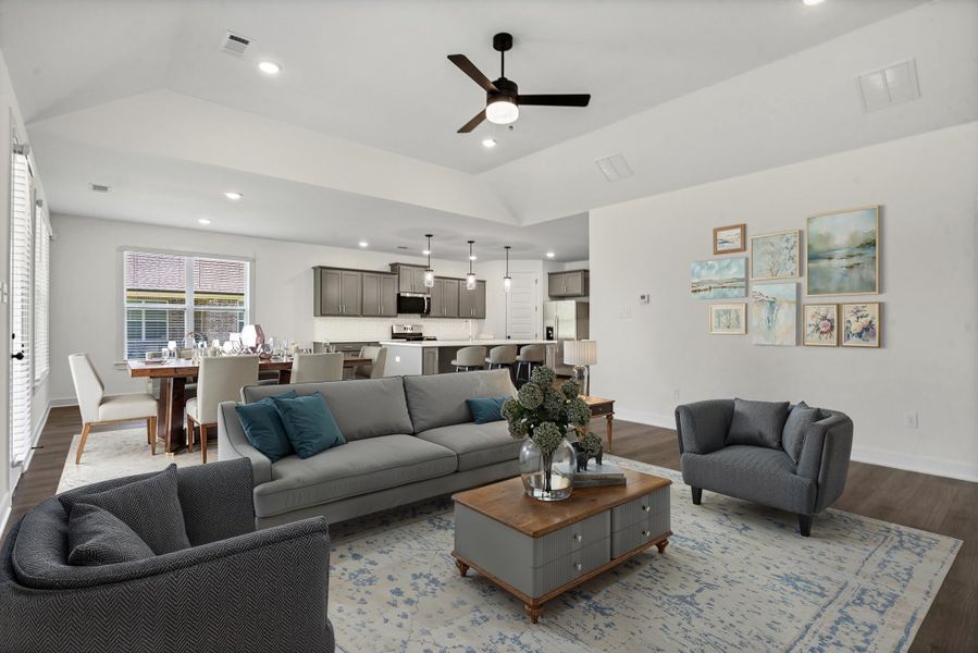Vaulted ceilings with recessed lighting and a ceiling fan, wood-finish flooring, and white walls define this open concept space Vaulted ceilings with recessed lighting and a ceiling fan, wood-finish flooring, and white walls define this open concept space