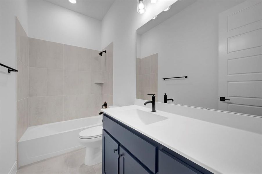 Bathroom with vanity, tub / shower combination, and light tile patterned floors