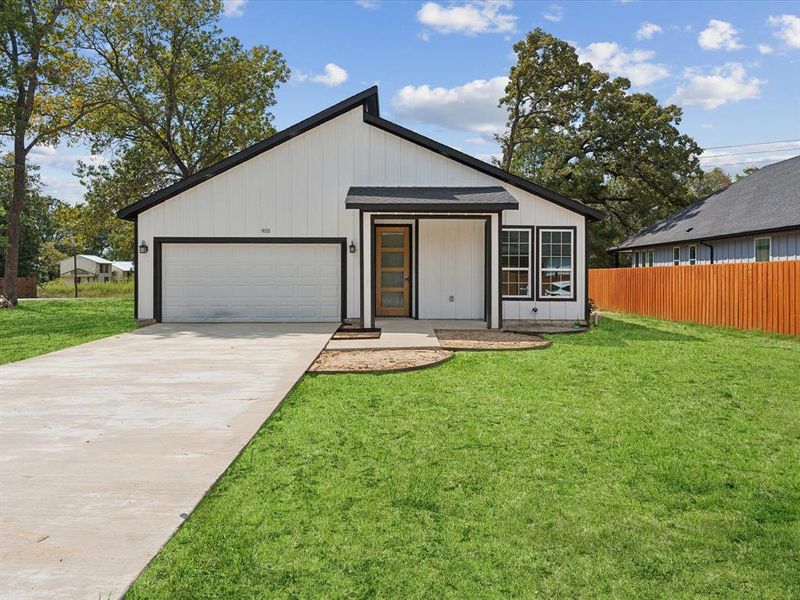 View of front of house with a front lawn and a garage