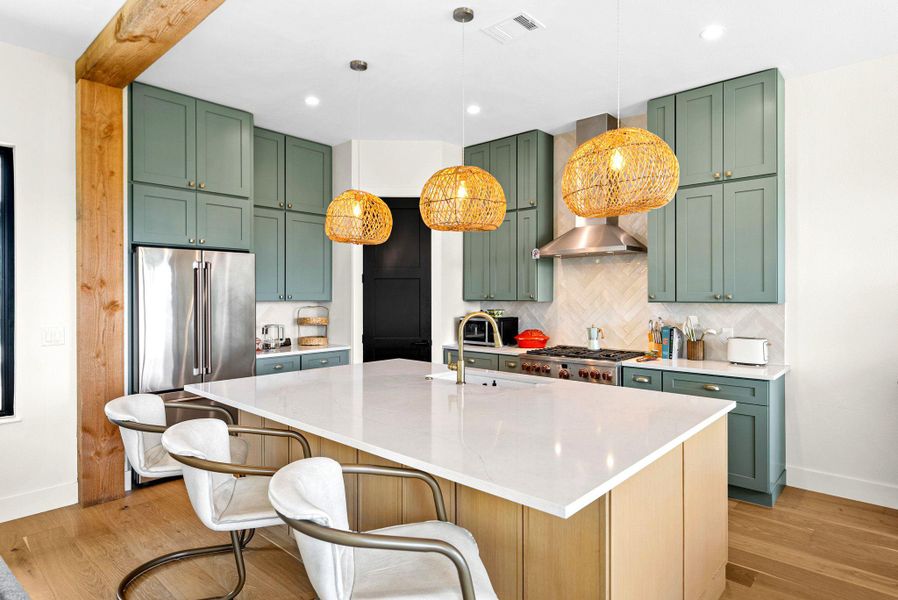 Exquisite wood flooring and a massive central island define this modern culinary space.