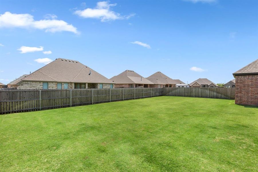 Fenced backyard with a residential view Fenced backyard with a residential view