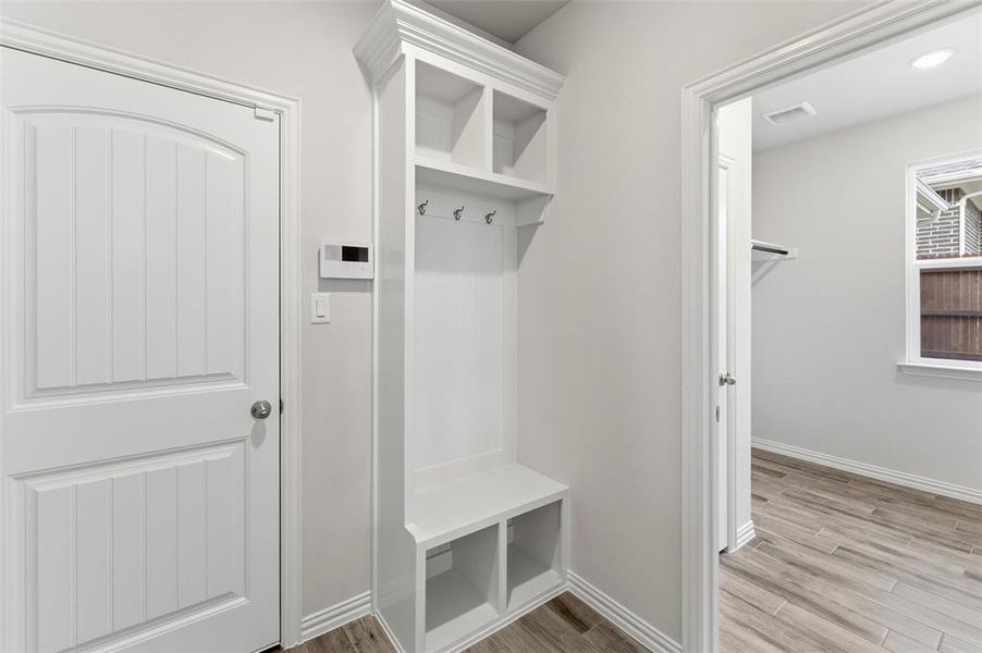 Mudroom with light wood-style floors and baseboards