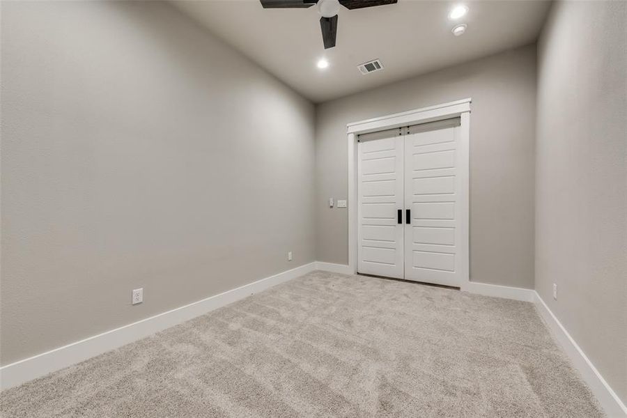 Unfurnished bedroom with ceiling fan, light colored carpet, and a closet