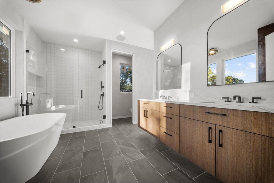 Bathroom featuring double vanity, a freestanding tub, a shower stall, and a linen closet (not shown in this picture)