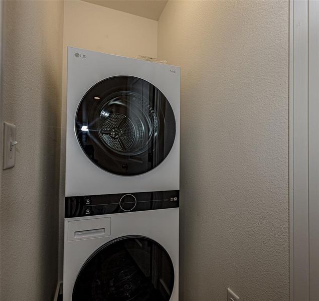 Utility closet featuring stacked washer / dryer - New LG with outstanding features