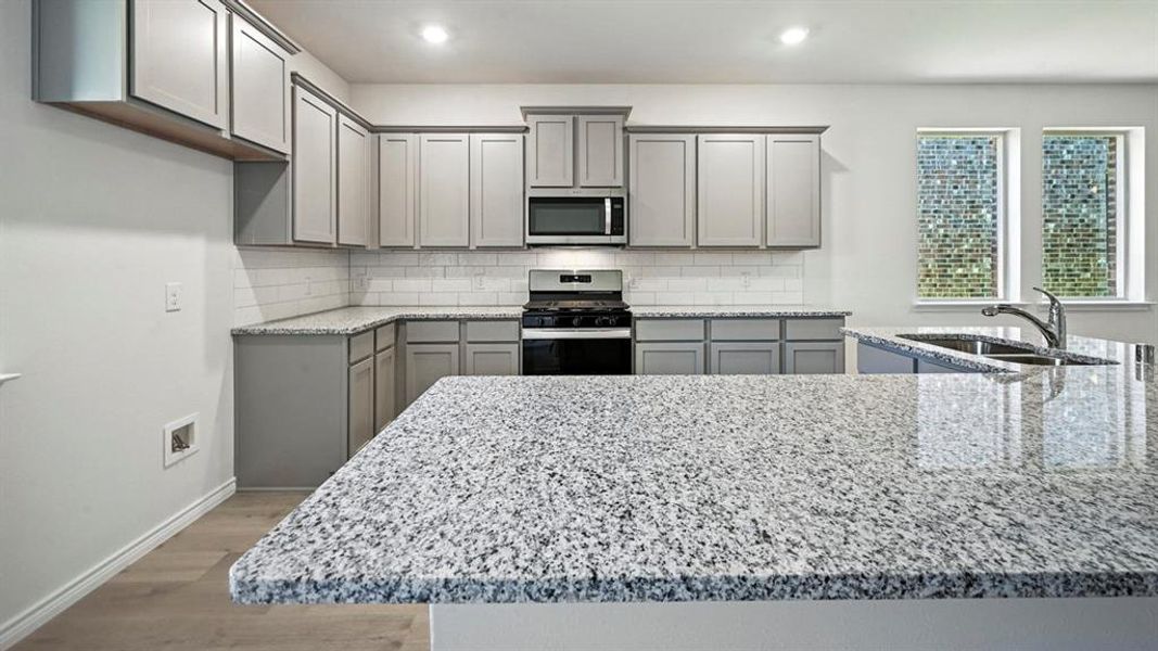 Kitchen featuring gray cabinets, light stone countertops, appliances with stainless steel finishes, backsplash, and recessed lighting Kitchen featuring gray cabinets, light stone countertops, appliances with stainless steel finishes, backsplash, and recessed lighting