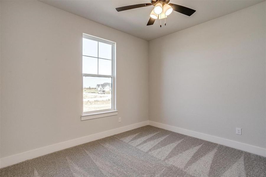 Carpeted empty room featuring ceiling fan