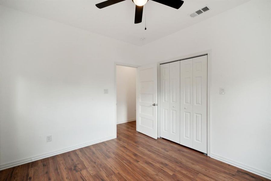 Unfurnished bedroom featuring a closet, ceiling fan, and dark hardwood / wood-style floors