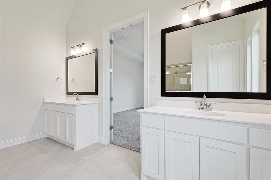 Bathroom featuring vanity, vaulted ceiling, an enclosed shower, and tile patterned floors