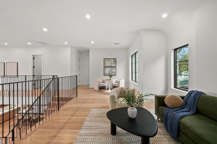 Living area with light wood finished floors, recessed lighting, and an upstairs landing Living area with light wood finished floors, recessed lighting, and an upstairs landing