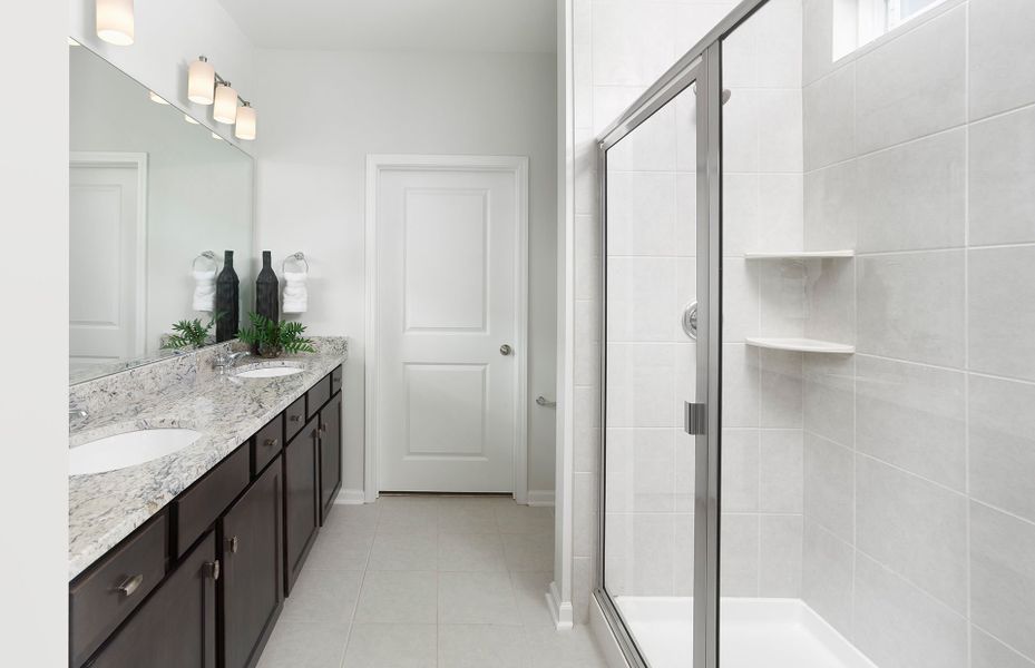 Elegant Owner's Bath with a tile walk-in shower and spacious dual vanity.