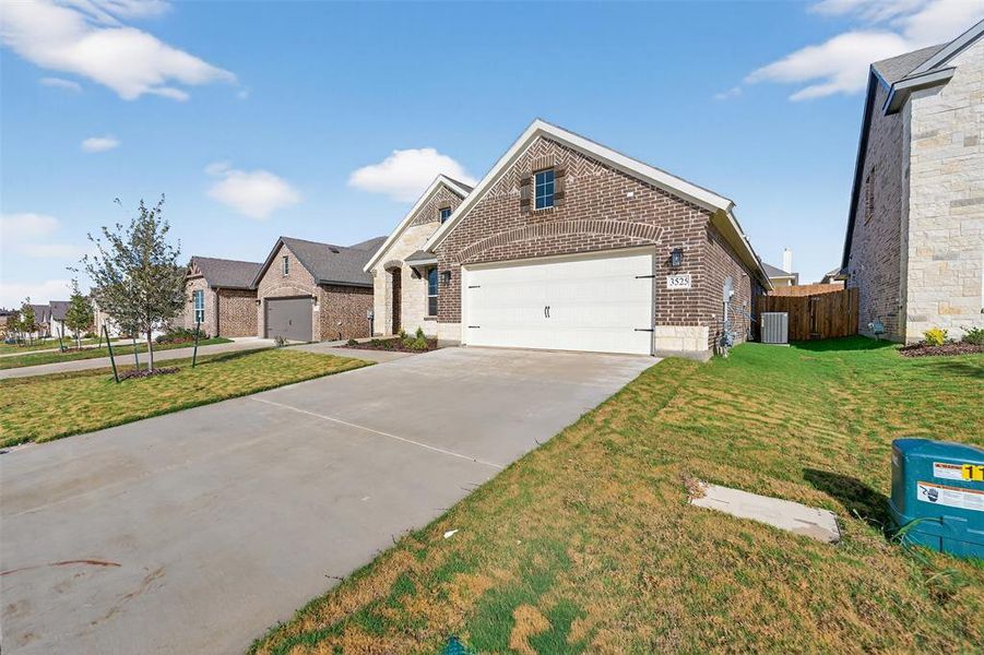View of front of property with brick siding, driveway, and an attached garage