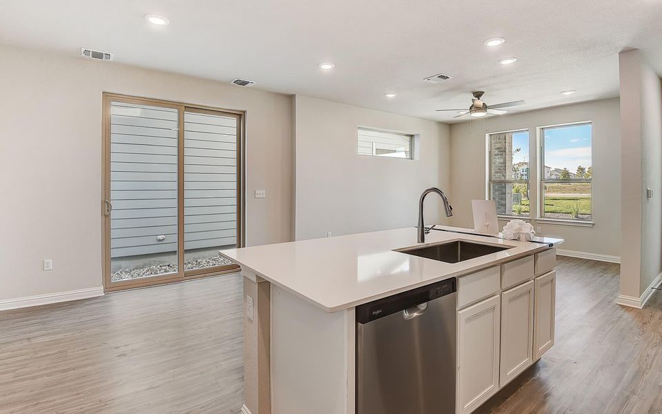 Kitchen with dishwasher, a center island with sink, recessed lighting, light wood-style floors, and white cabinetry