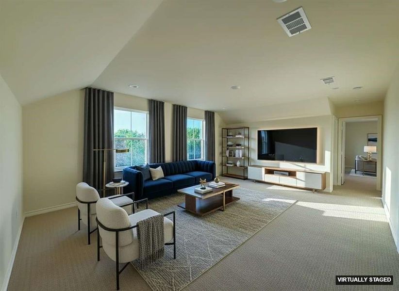 Carpeted living area with lofted ceiling and baseboards Carpeted living area with lofted ceiling and baseboards