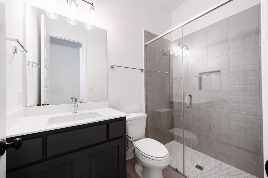 Full bath with toilet, vanity, and a stall shower Full bath with toilet, vanity, and a stall shower