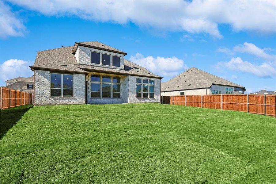 Back of house featuring a yard