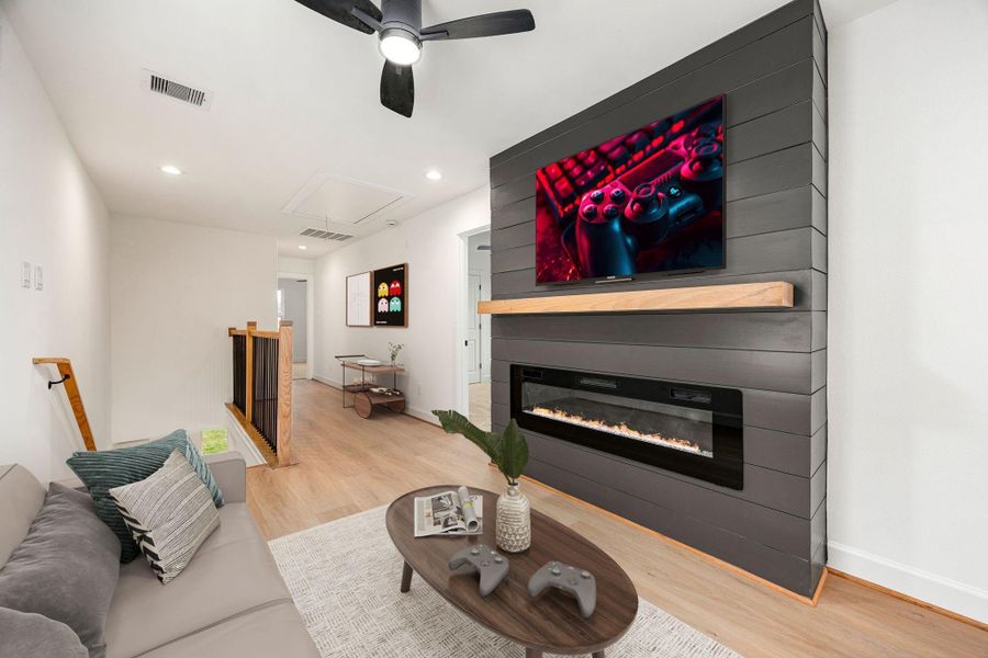 An upstairs living area offers a cozy retreat with a striking modern fireplace feature, clean lines, and an open layout that provides flexibility for a media room, lounge, or additional entertaining space.