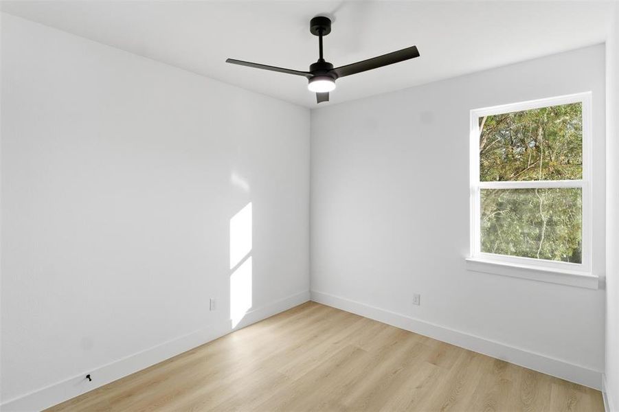 Spare room featuring light wood-style flooring and ceiling fan