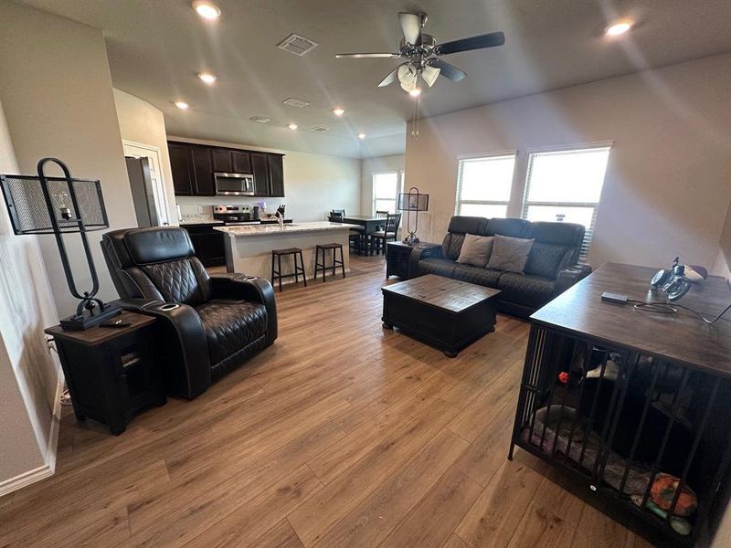 Living area featuring recessed lighting, dark wood-type flooring, and a ceiling fan