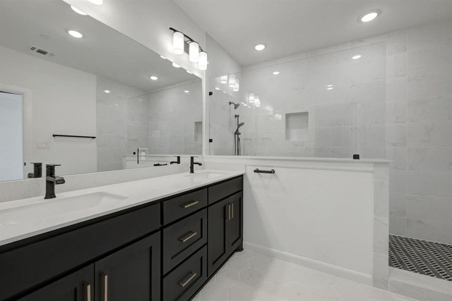 Bathroom featuring a dual vanity with dark wood-finish cabinetry and light-toned countertops Bathroom featuring a dual vanity with dark wood-finish cabinetry and light-toned countertops