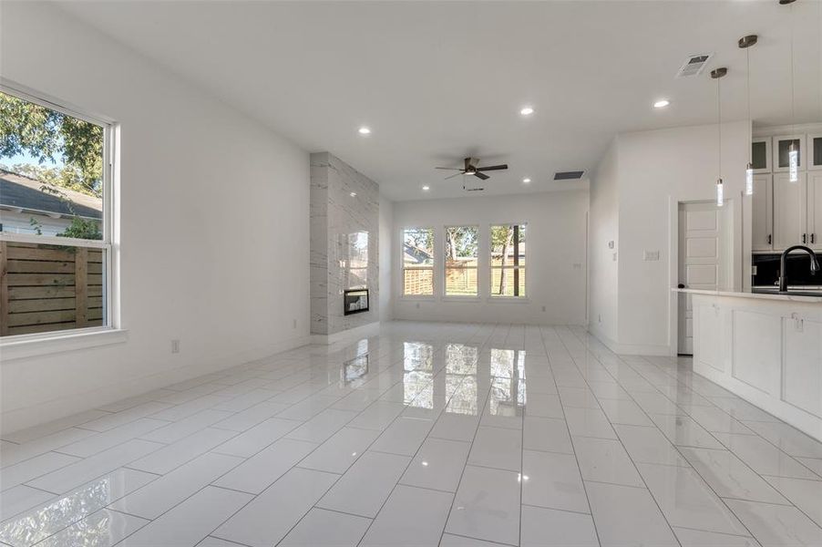 Unfurnished living room featuring recessed lighting, a fireplace, ceiling fan, and light tile patterned floors