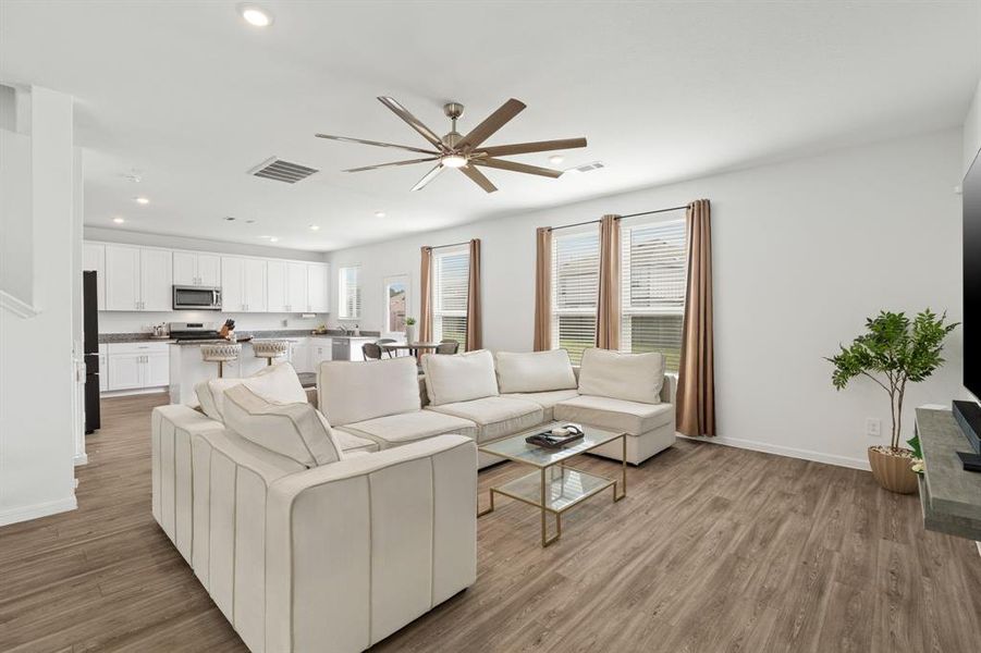 An open concept floorplan, fabulous flooring and natural lighting from WALL OF WINDOWS greet you upon entry into this Luxurious Living Room!