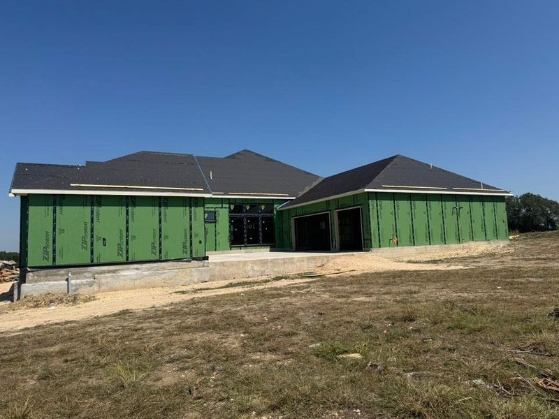 Rear view of house with a patio and a lawn