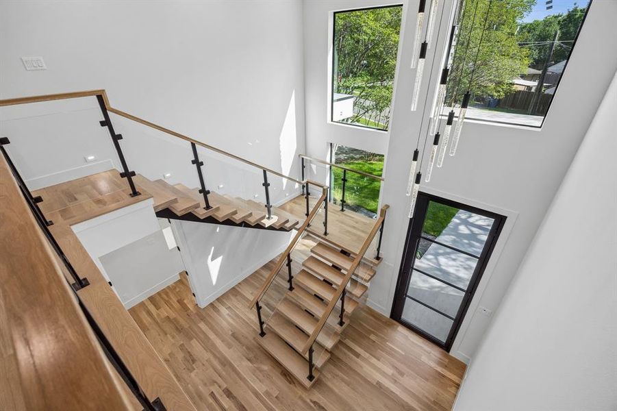 The impressive entry greets visitors with a floating stair, double height windows, glass railings and a beautiful chandelier