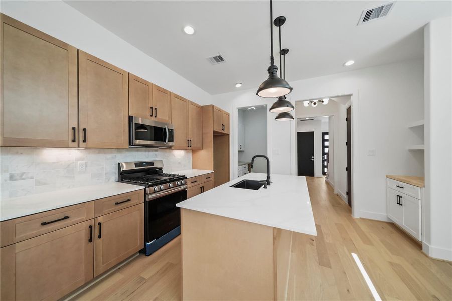 Savor culinary elegance in this kitchen with Calacatta countertops, chic pendant lighting, and premium stainless steel appliances. Savor culinary elegance in this kitchen with Calacatta countertops, chic pendant lighting, and premium stainless steel appliances.