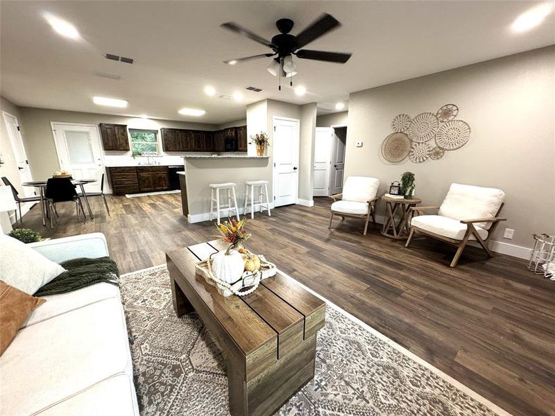 Living area featuring dark wood-style floors, a ceiling fan, and recessed lighting